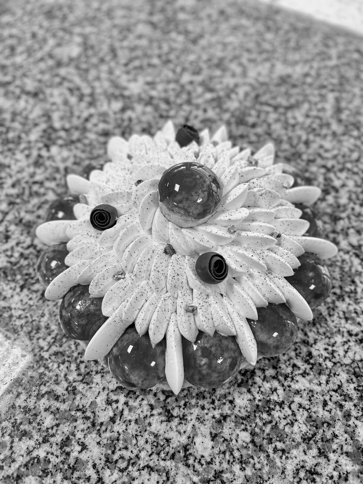 Entremet en forme de fleur dressé sur un plan de travail en granit